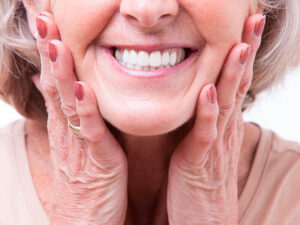 idosa sorrindo após colocar implantes